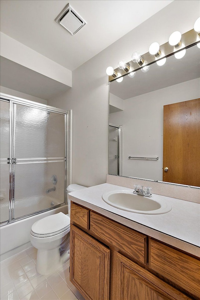 full bathroom featuring tile patterned floors, visible vents, toilet, combined bath / shower with glass door, and vanity