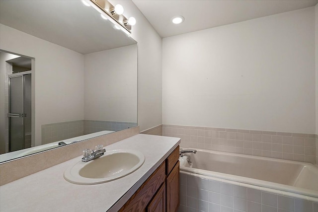 bathroom featuring vanity, a garden tub, and a shower stall