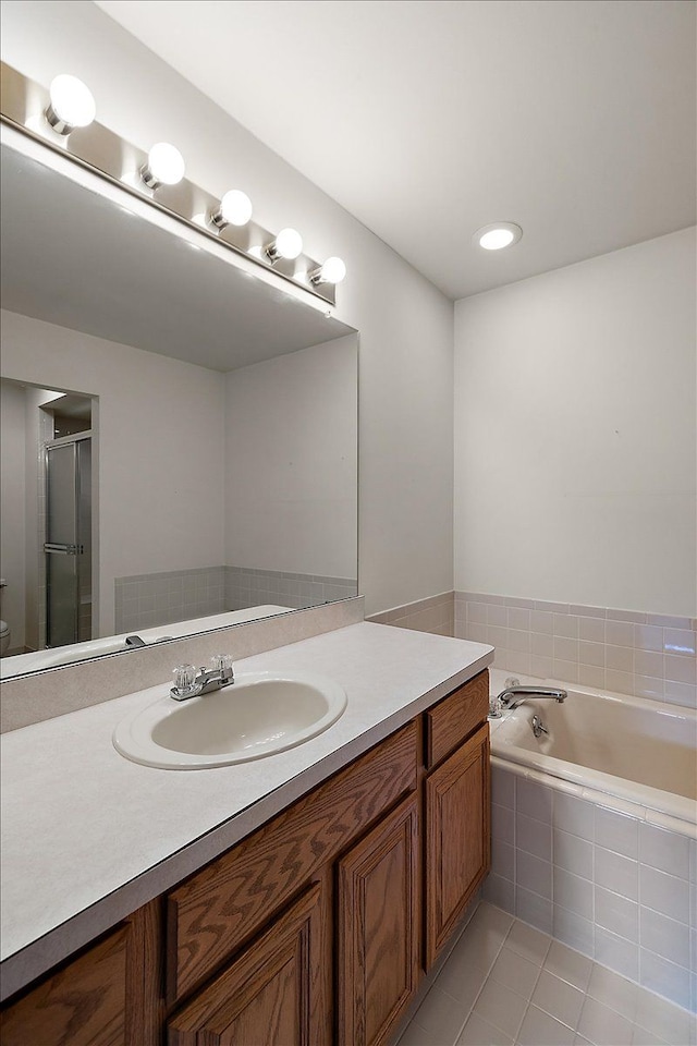 full bath with tile patterned floors, a garden tub, a shower stall, and vanity