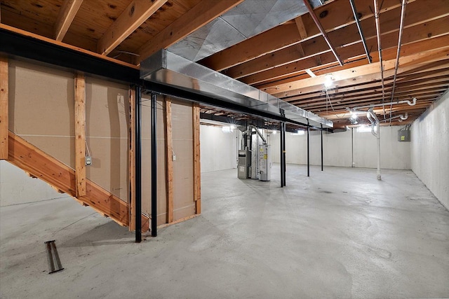 unfinished basement with electric panel and gas water heater