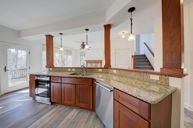 kitchen featuring beverage cooler, dishwasher, a wealth of natural light, and a sink