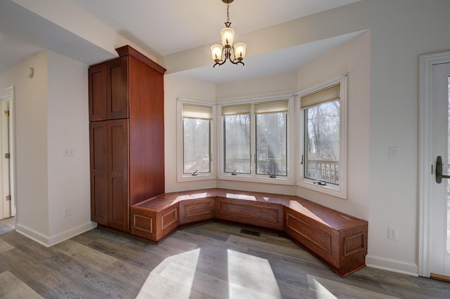 mudroom featuring a chandelier, visible vents, baseboards, and wood finished floors