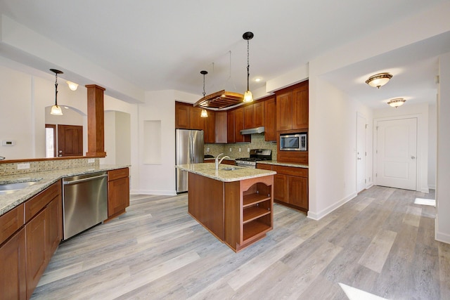 kitchen with under cabinet range hood, decorative backsplash, stainless steel appliances, and a sink