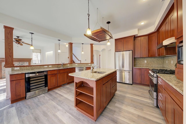 kitchen with light wood-style flooring, under cabinet range hood, open shelves, stainless steel appliances, and wine cooler