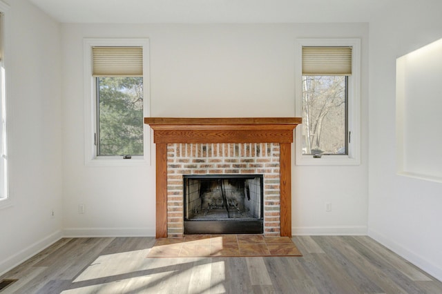 interior details featuring wood finished floors, a fireplace, baseboards, and visible vents