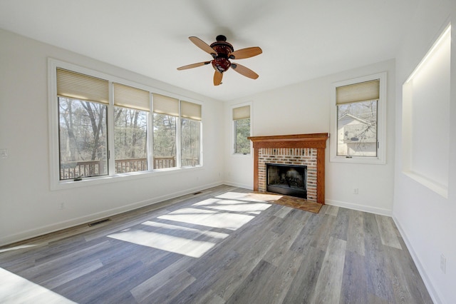 unfurnished living room featuring wood finished floors, visible vents, and baseboards