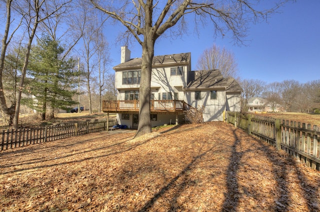 back of house with a wooden deck, a fenced backyard, and a chimney