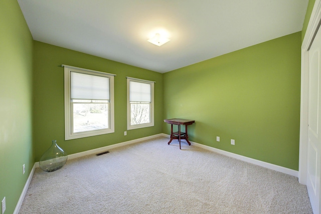 carpeted empty room featuring visible vents and baseboards