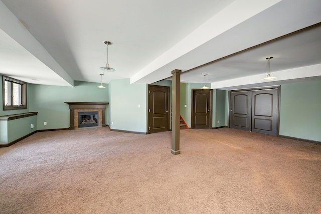 unfurnished living room with stairway, baseboards, carpet, and a glass covered fireplace