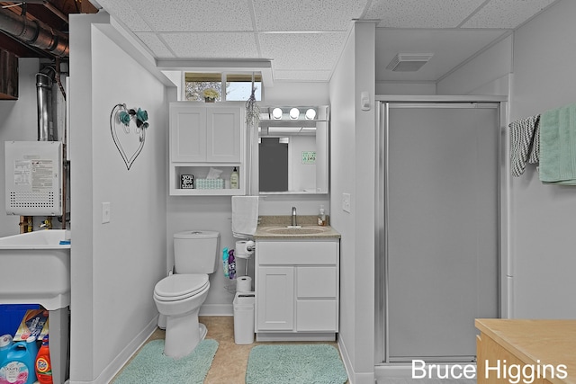 bathroom with vanity, baseboards, a shower stall, a paneled ceiling, and toilet