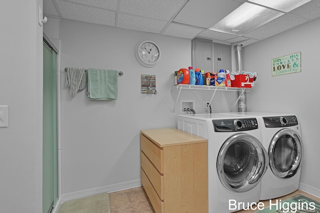 washroom featuring laundry area, washing machine and dryer, and baseboards