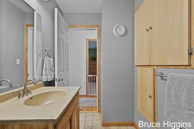 bathroom featuring tile patterned floors, baseboards, and vanity