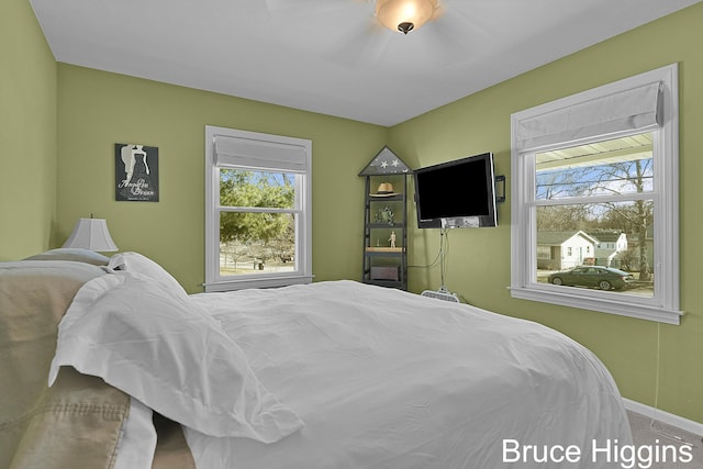 carpeted bedroom with baseboards and multiple windows