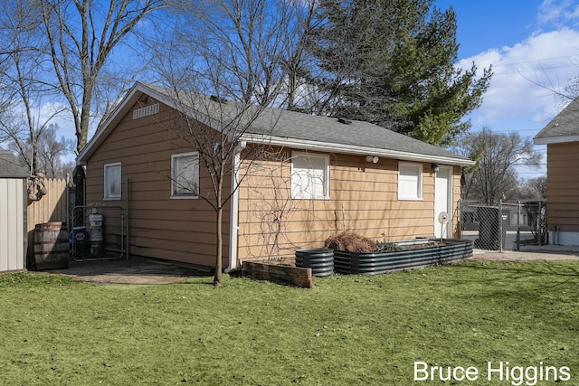 view of side of home featuring a yard and fence