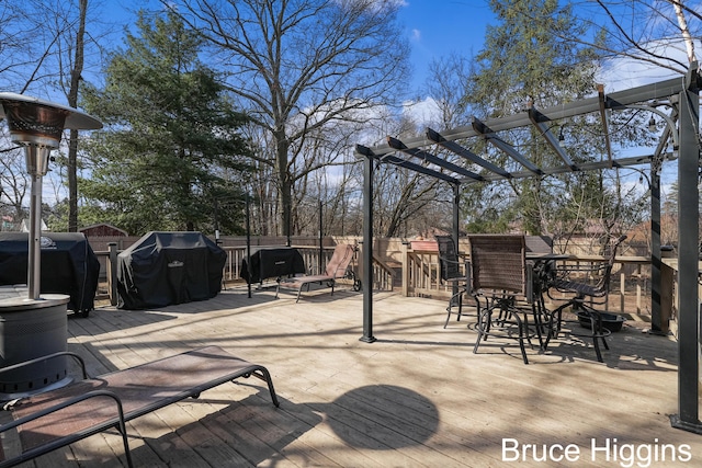 deck featuring area for grilling, fence, and a pergola