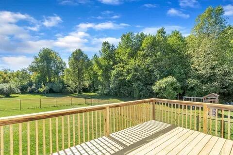 wooden terrace featuring a lawn and fence