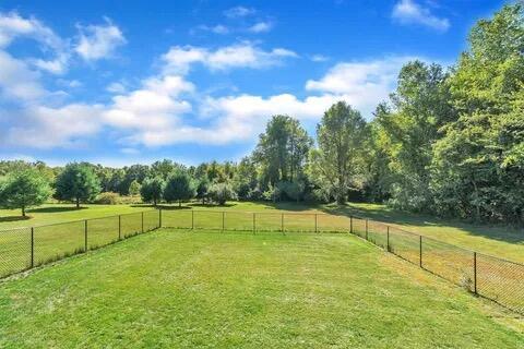 view of yard featuring a rural view and a fenced backyard