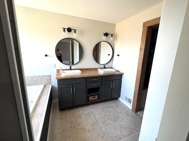 bathroom with tile patterned flooring, double vanity, visible vents, and a sink