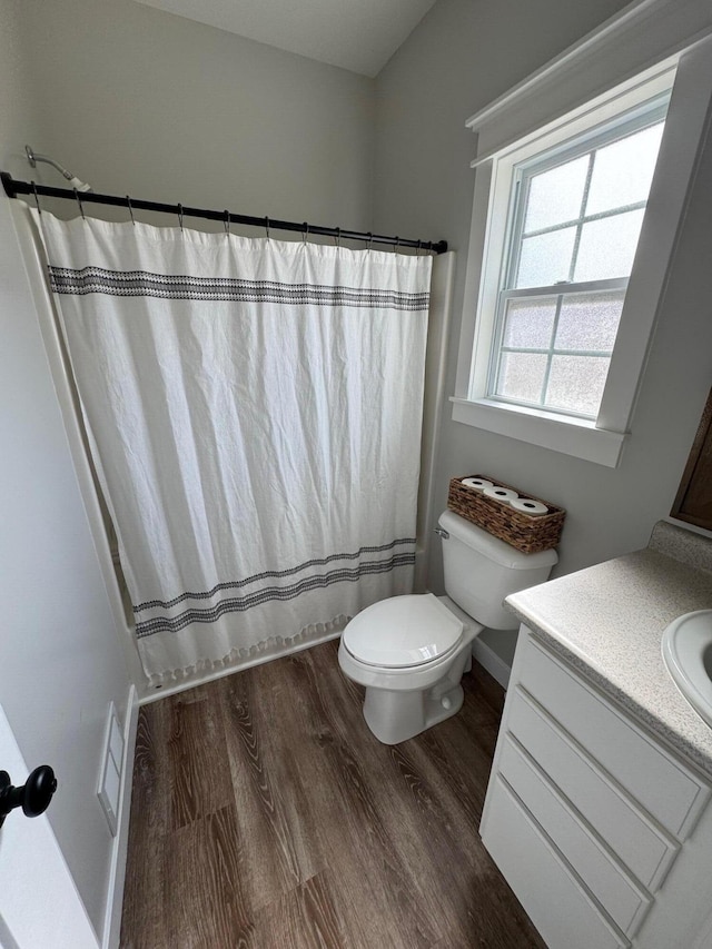 bathroom featuring visible vents, a shower with curtain, toilet, wood finished floors, and vanity