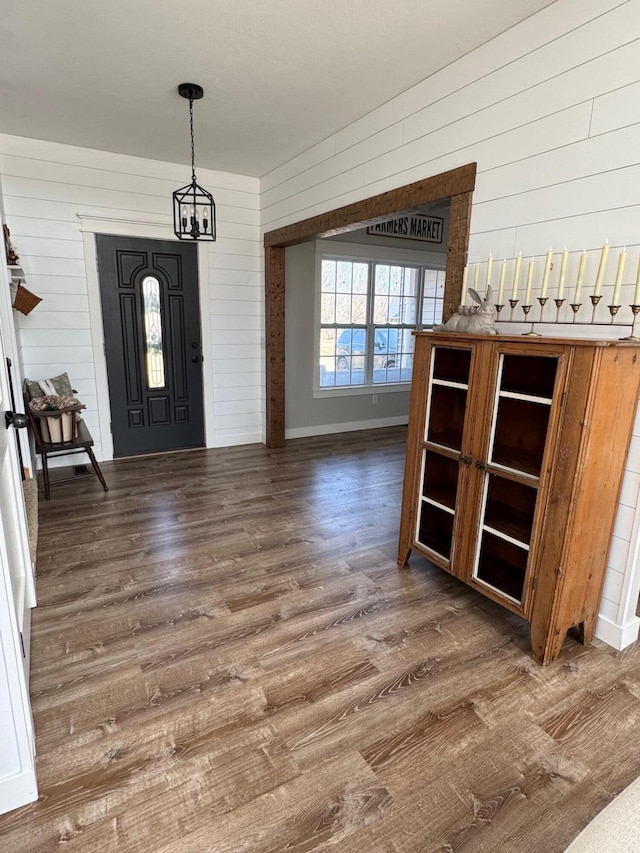 entrance foyer featuring an inviting chandelier, wood finished floors, and baseboards