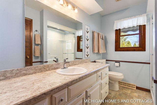 full bathroom featuring visible vents, toilet, a shower with door, baseboards, and vanity