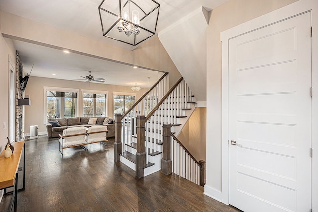 interior space featuring baseboards, dark wood finished floors, stairs, recessed lighting, and ceiling fan with notable chandelier