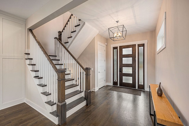 foyer featuring stairs, dark wood-style floors, baseboards, and a chandelier