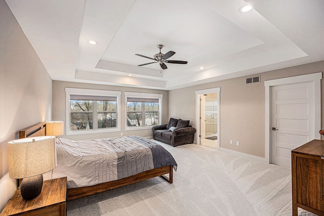 bedroom with visible vents, a raised ceiling, light colored carpet, and baseboards