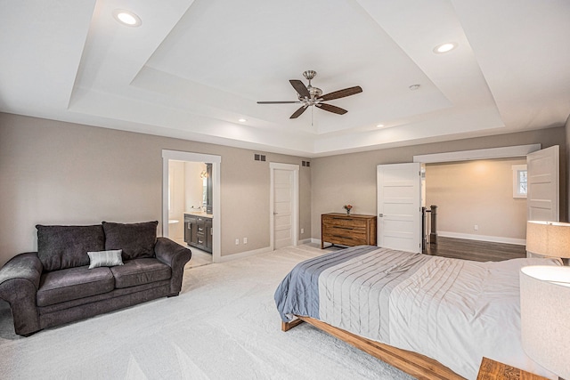 bedroom featuring a tray ceiling, baseboards, and visible vents