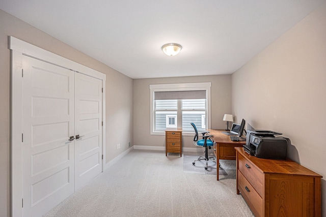 home office with baseboards and light carpet