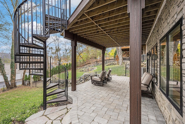 view of patio with stairs and fence