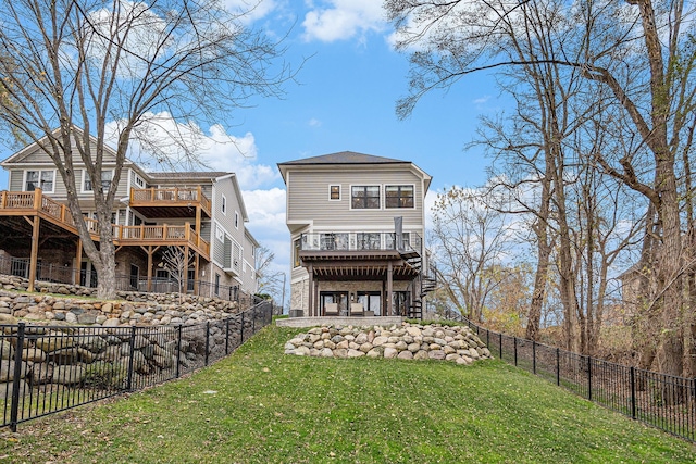 back of house featuring a yard, a fenced backyard, a wooden deck, and stairway