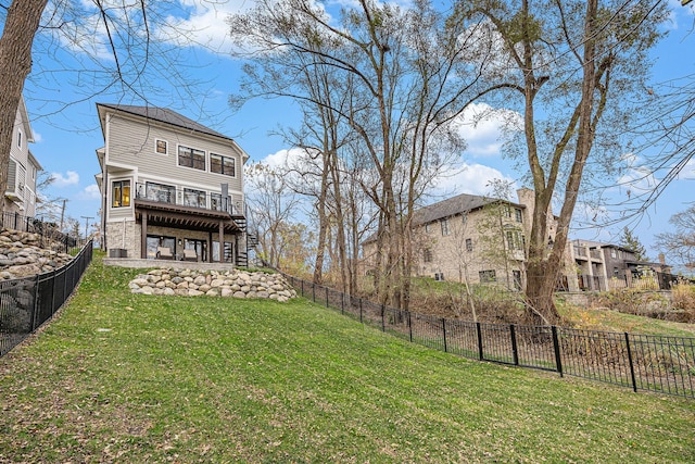 rear view of house featuring stairway, a lawn, a wooden deck, and a fenced backyard