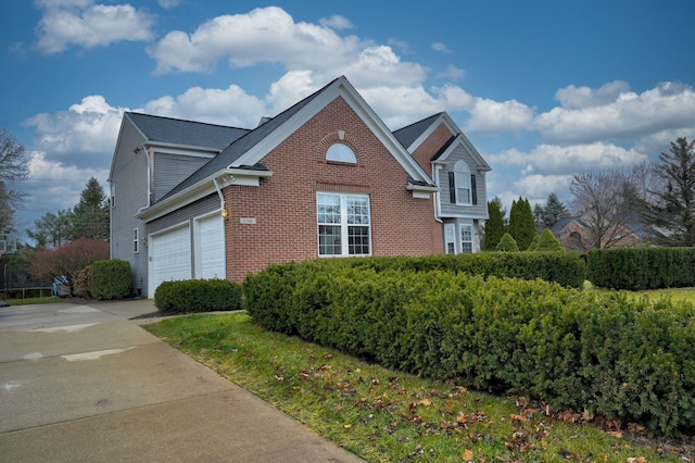 view of property exterior with a garage, brick siding, and driveway