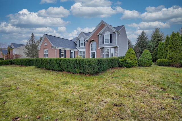 traditional home with brick siding and a front yard