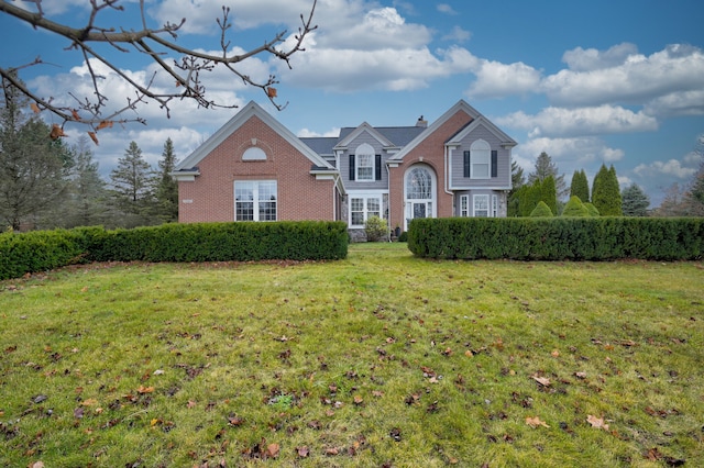 traditional home with a front lawn, brick siding, and a chimney