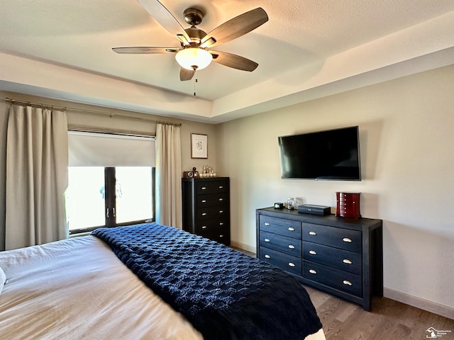 bedroom with baseboards, light wood-style floors, and a ceiling fan