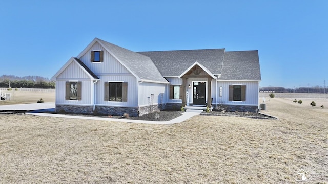 modern inspired farmhouse featuring a shingled roof and a front lawn