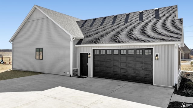 view of property exterior featuring board and batten siding, roof with shingles, concrete driveway, and an attached garage