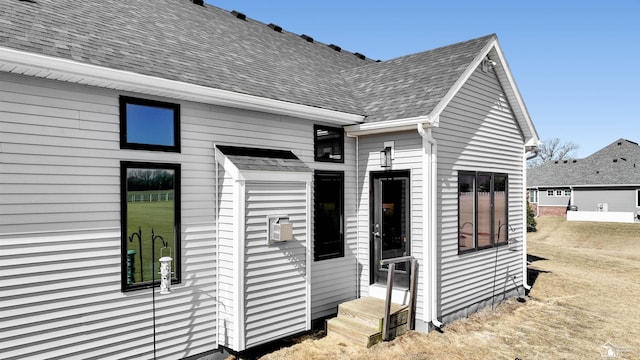 view of home's exterior featuring roof with shingles and entry steps