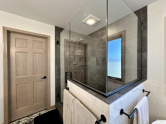 full bathroom featuring a textured ceiling, tile walls, and walk in shower