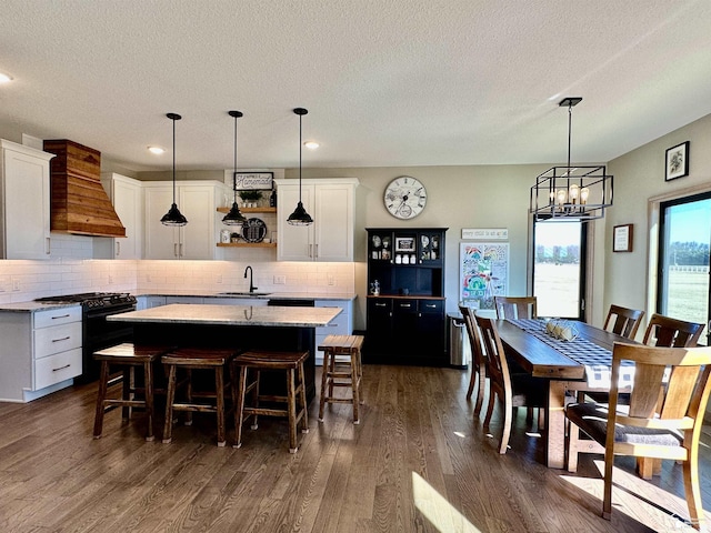 dining space featuring recessed lighting, a notable chandelier, a textured ceiling, and dark wood finished floors