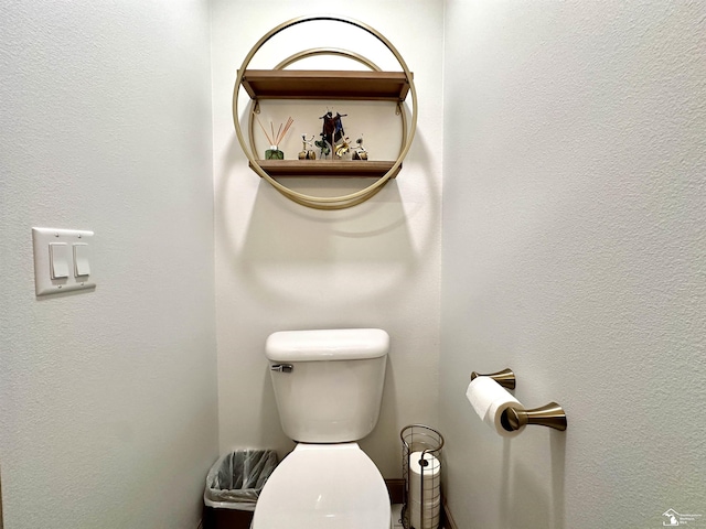 bathroom with toilet and a textured wall