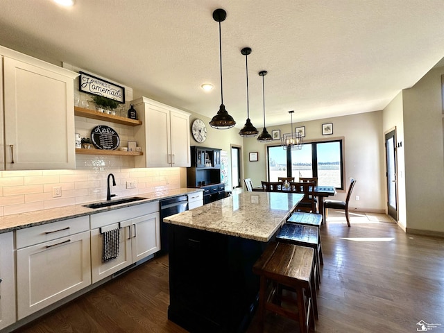 kitchen with tasteful backsplash, a sink, open shelves, a kitchen island, and dark wood-style flooring