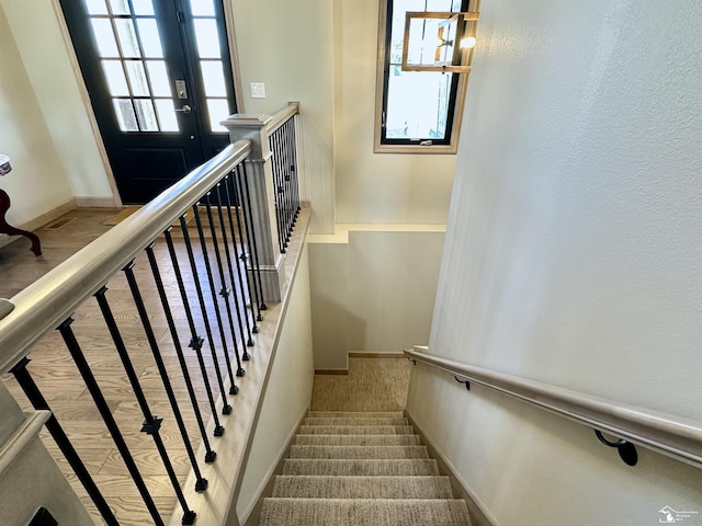 stairs with wood finished floors and baseboards