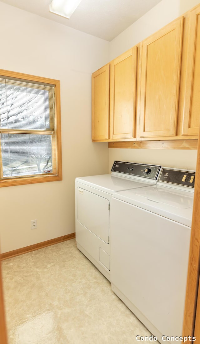 washroom with baseboards, cabinet space, and separate washer and dryer