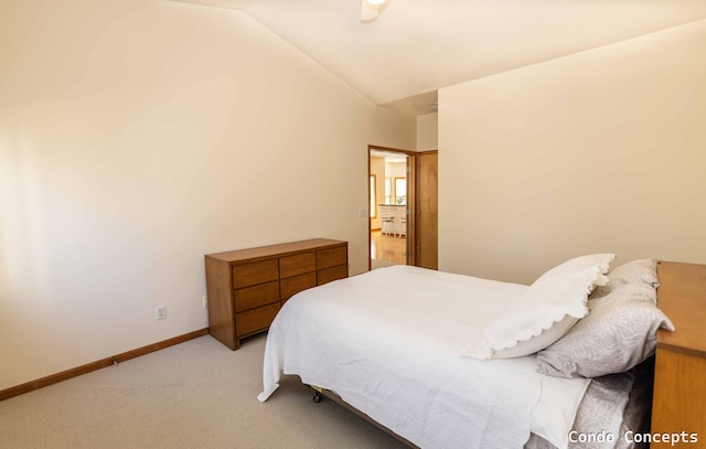 carpeted bedroom featuring baseboards and vaulted ceiling