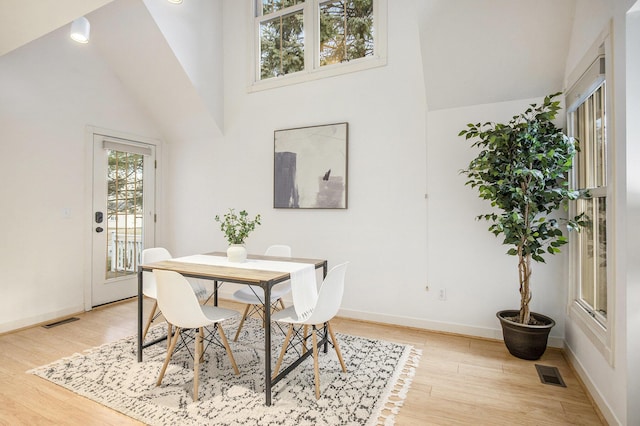 dining room featuring visible vents, baseboards, and light wood finished floors