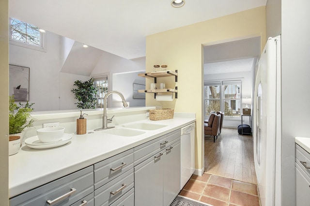 kitchen featuring a wealth of natural light, white appliances, light countertops, and a sink