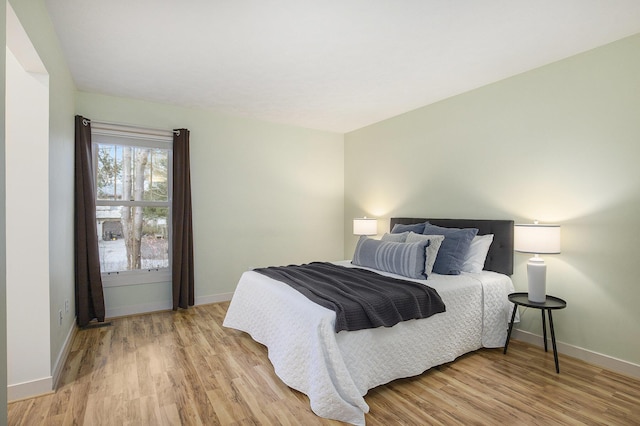 bedroom featuring light wood-type flooring and baseboards